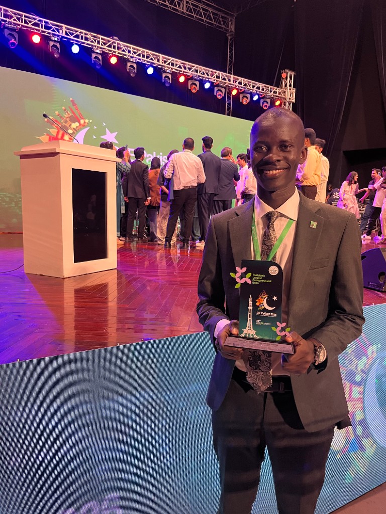 Caleb Jephunneh holding the SEE Pakistan international winner trophy